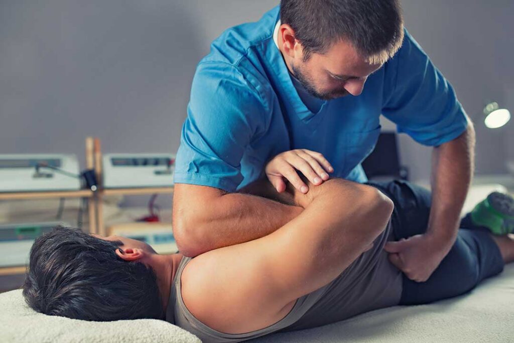 A chiropractor performing a gentle spinal adjustment on a middle-aged patient in a calm clinical setting.