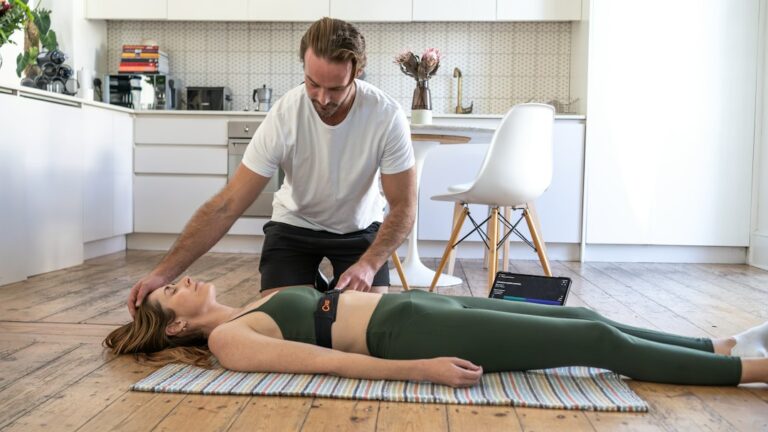 Person receiving a careful spine movement assessment while seated in a bright clinical room.